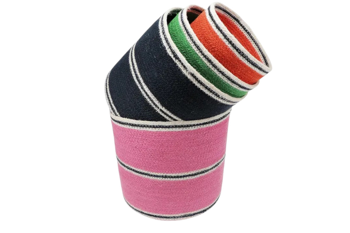 FINCHCRAFT set of four round woven jute storage baskets in pink, navy, green, and orange with striped detailing.