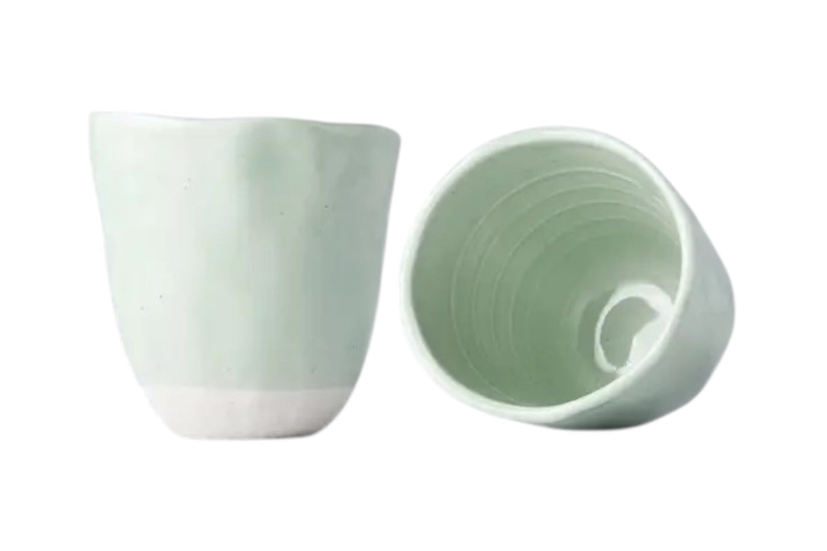 FINCHCRAFT Tomei blue glazed earthenware mug with an irregular, lopsided shape and a smooth, hand-finished texture.