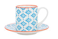 A porcelain espresso cup and saucer with a blue patterned finish and subtle orange accents, ictured on a white background.