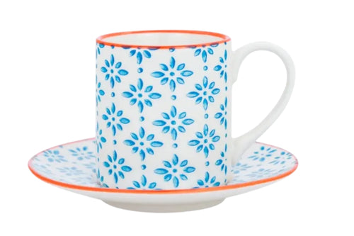 A porcelain espresso cup and saucer with a blue patterned finish and subtle orange accents, ictured on a white background.