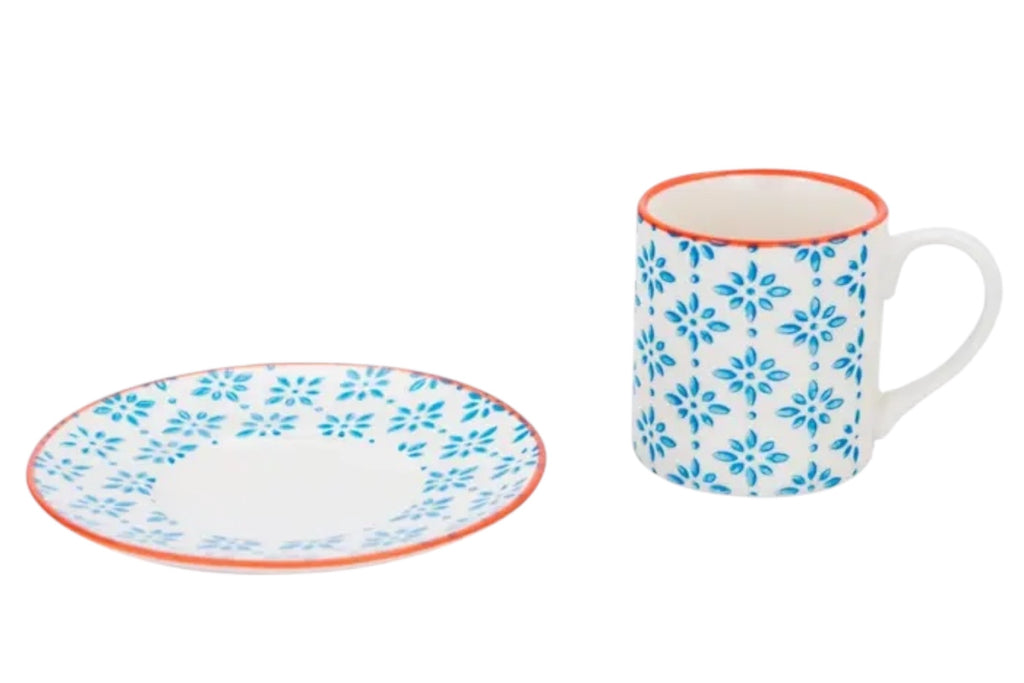 A porcelain espresso cup and saucer with a blue patterned finish and subtle orange accents, ictured on a white background.