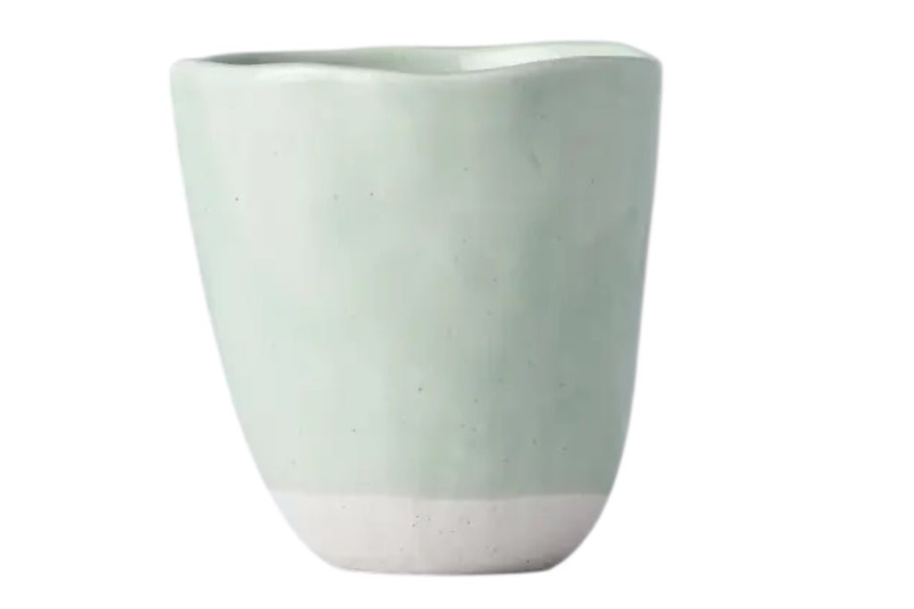 A hand-finished ceramic mug with a softly irregular form and pale tomei blue glaze set against a white background.