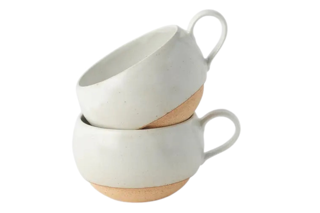 Two Rounded White Earthenware Mugs with bare clay bases, on a whiote background.