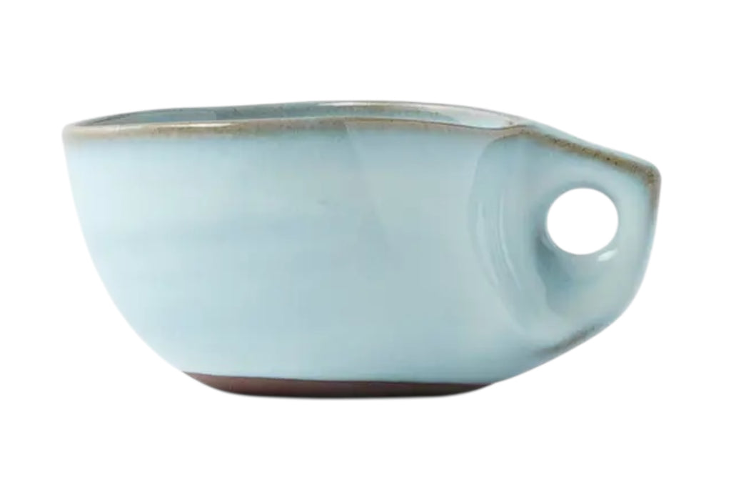 A ceramic coffee cup with a soft cloud blue glaze and curved handle set against a white background.