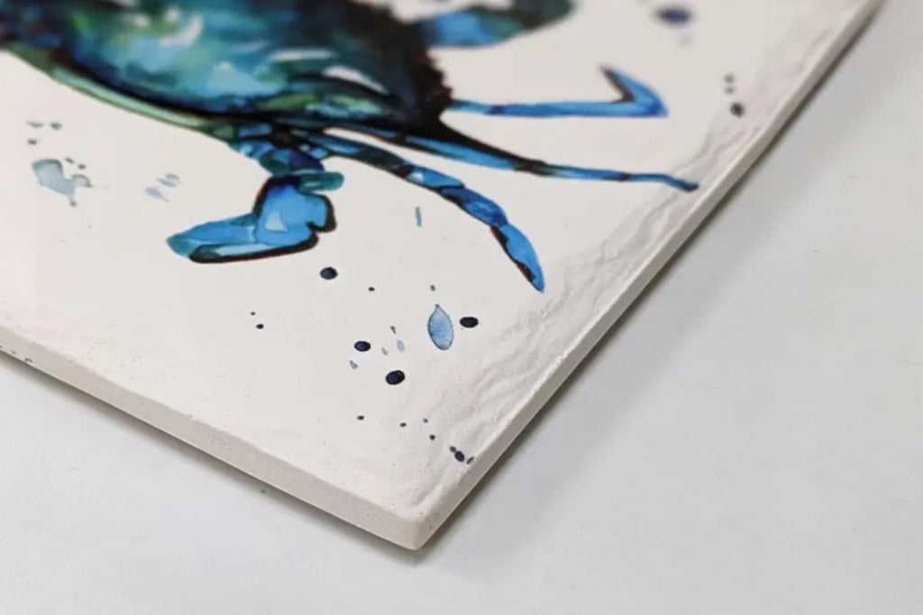 A close up of a ceramic trivet with a crab illustration, set against a white background.