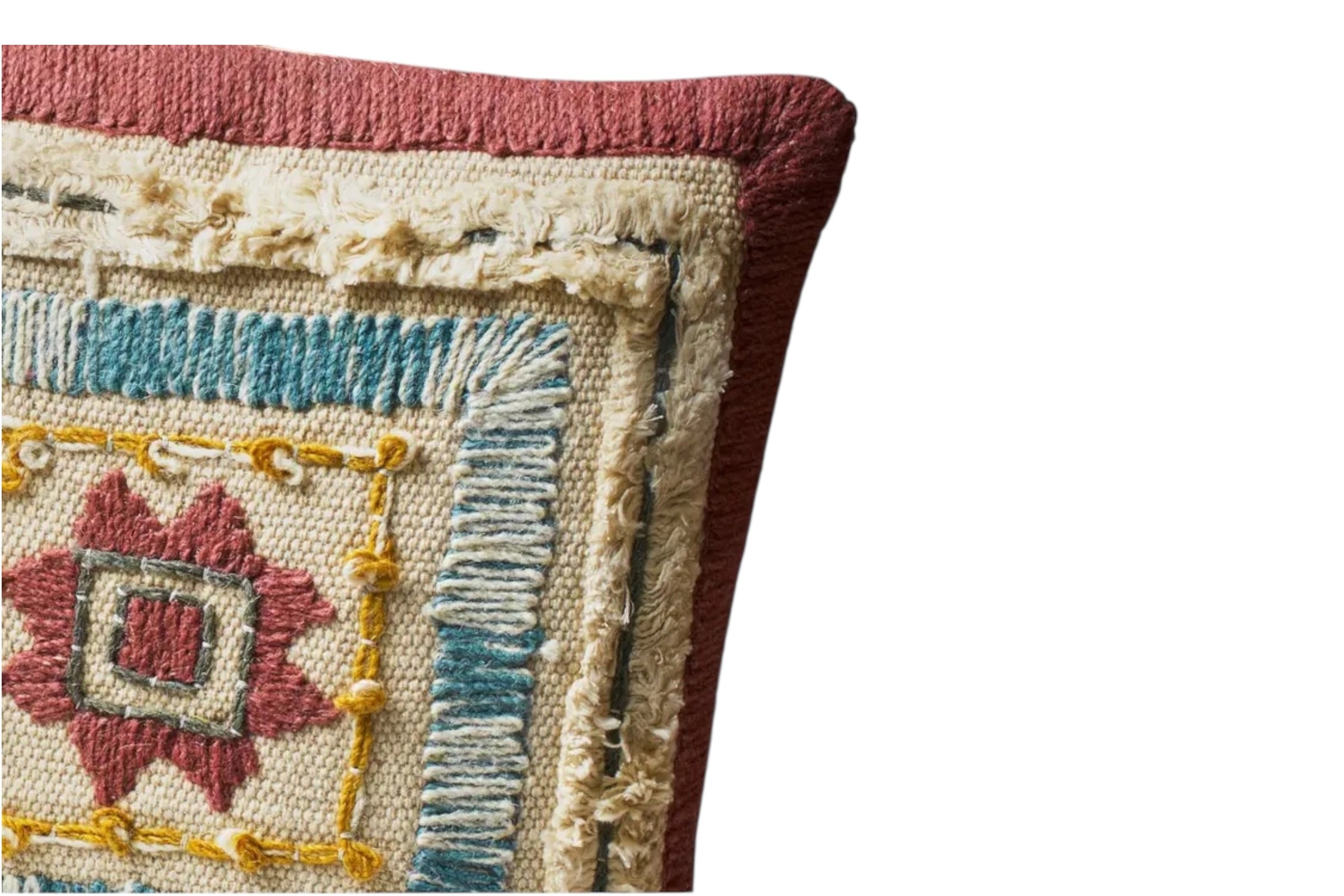 A close up of a cotton cushion with layered embroidery and a calm, multi-tonal palette. Set against a white background.