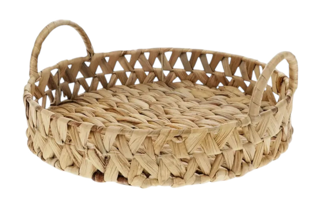 A circular tray woven from natural water hyacinth with integrated handles. Set against a white background.