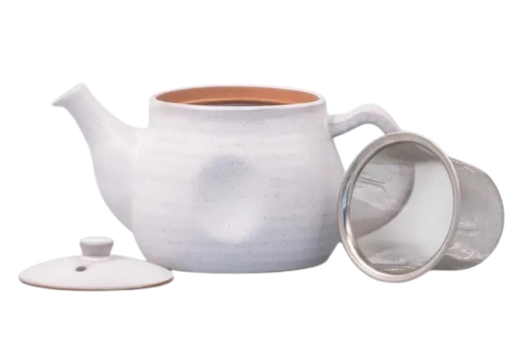 A white speckled japanese teapot with a ridge design, lid off ahowing a stainless steel strainer, set against a white background.