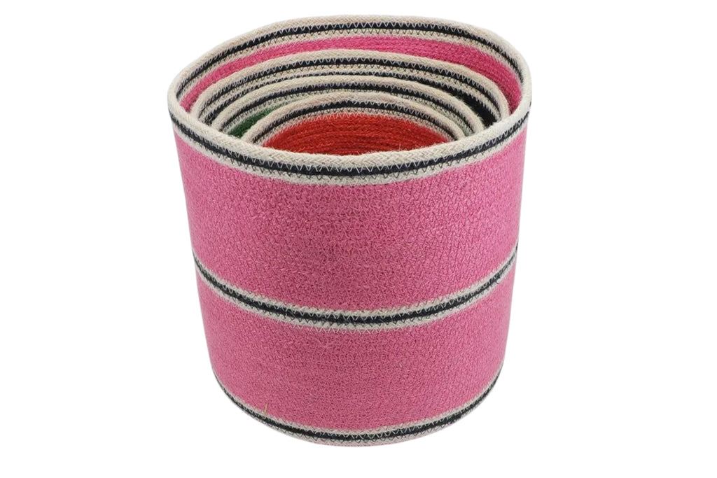 A set of four round jute storage baskets in graduated sizes and colours. Set against a white background.