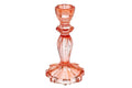 A tall orange glass candlestick with a fluted stem and flared base, pictured against a white background.