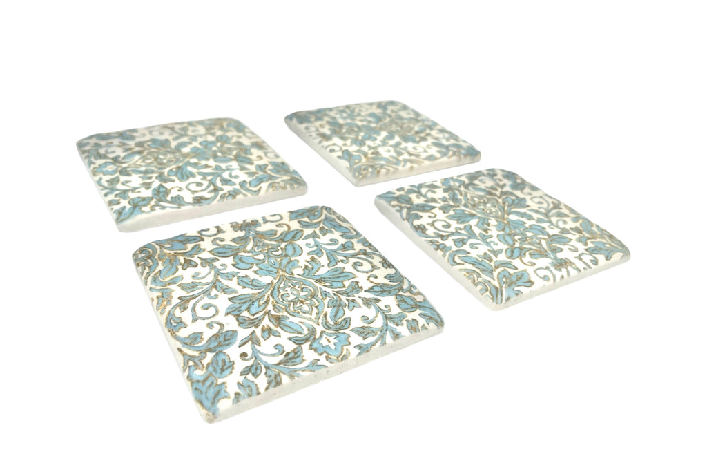 Set of four decorative coasters with floral patterns on a white background