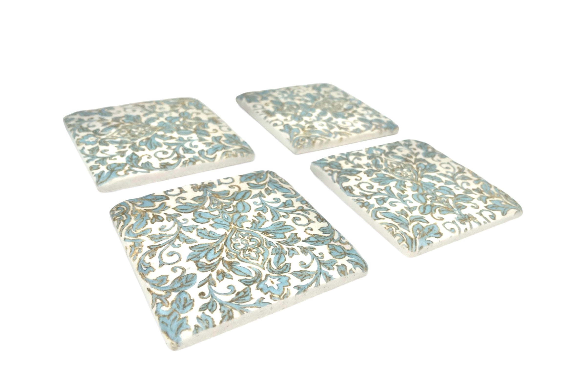 Set of four decorative coasters with floral patterns on a white background