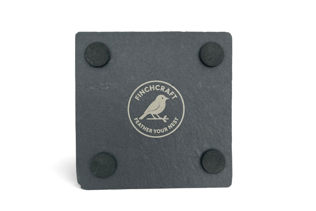 The underside of a slate coaster withe Finchcraft logo engraved, on a what background.