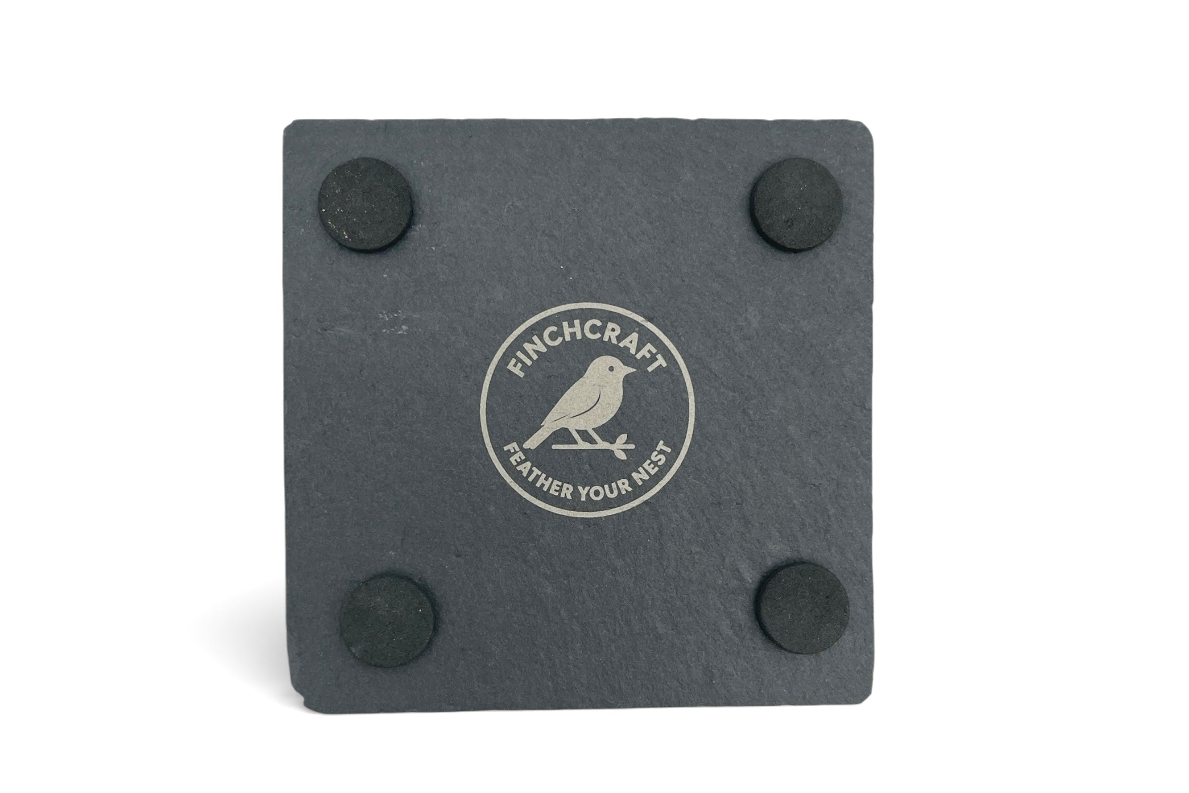 The underside of a slate coaster withe Finchcraft logo engraved, on a what background.