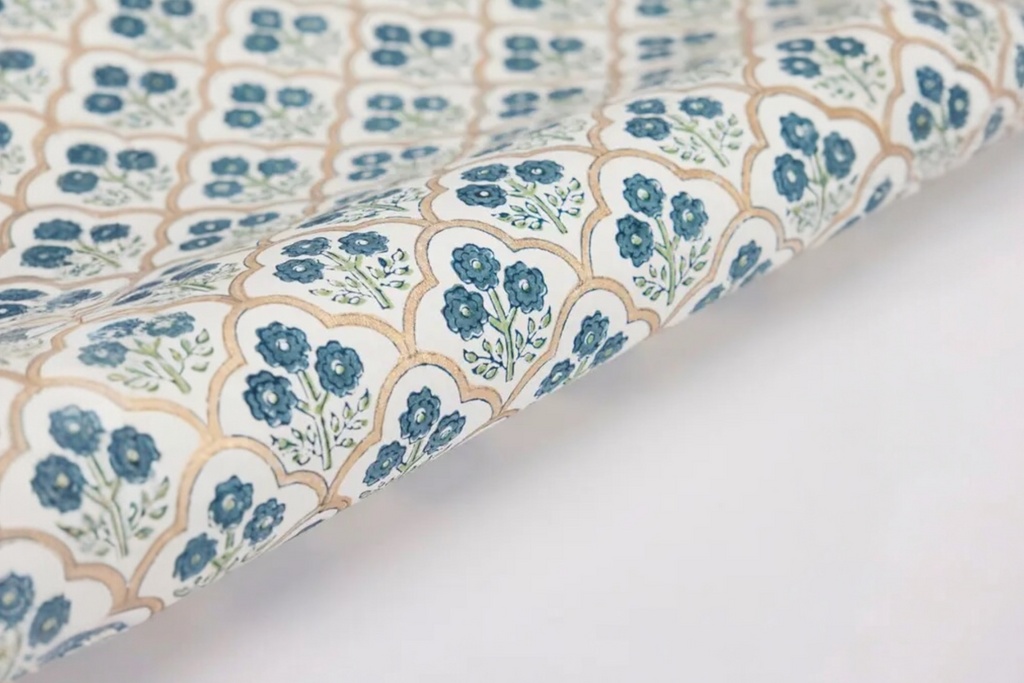 Some handmade, trellis indigo design wrapping paper on a white background.