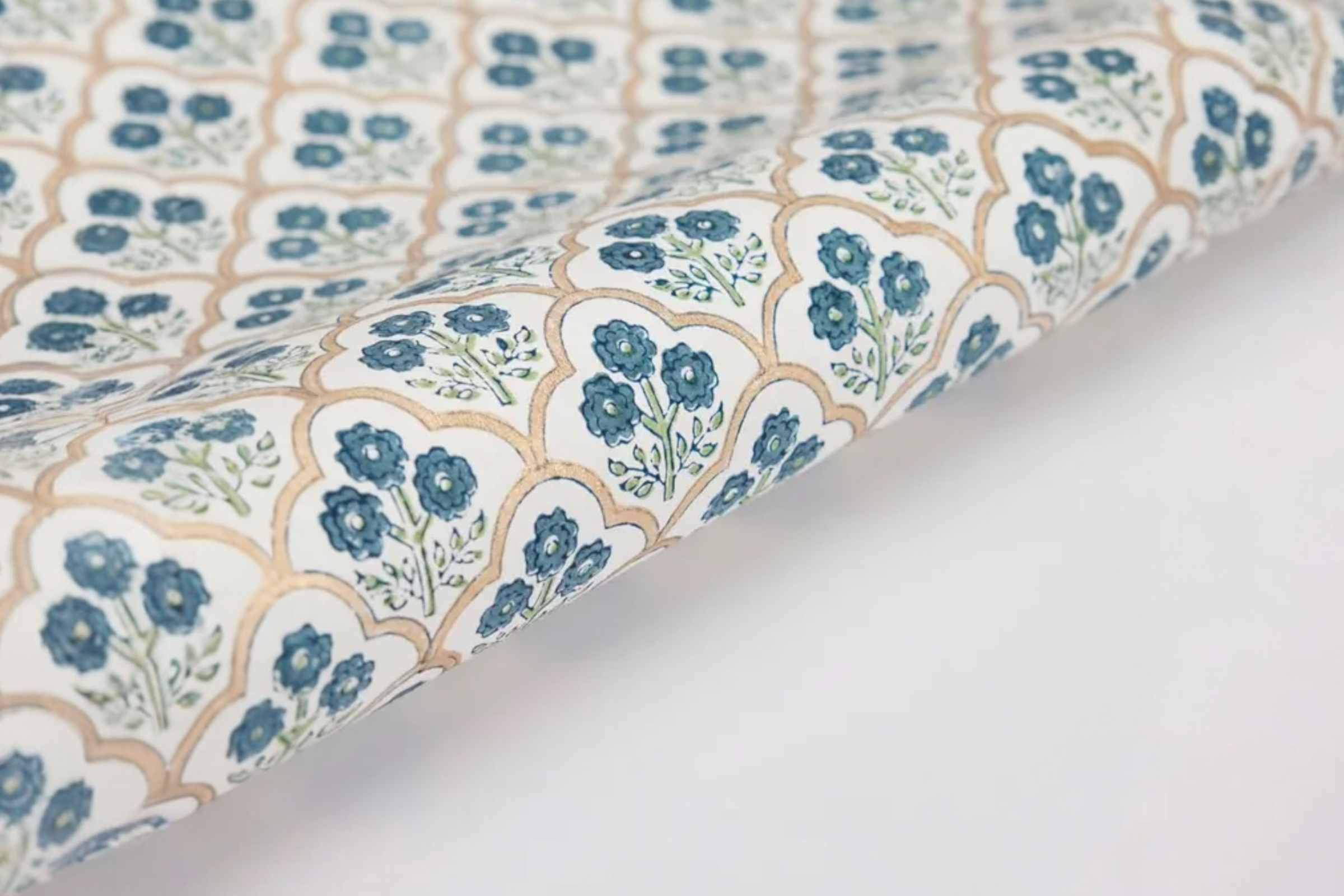 Some handmade, trellis indigo design wrapping paper on a white background.
