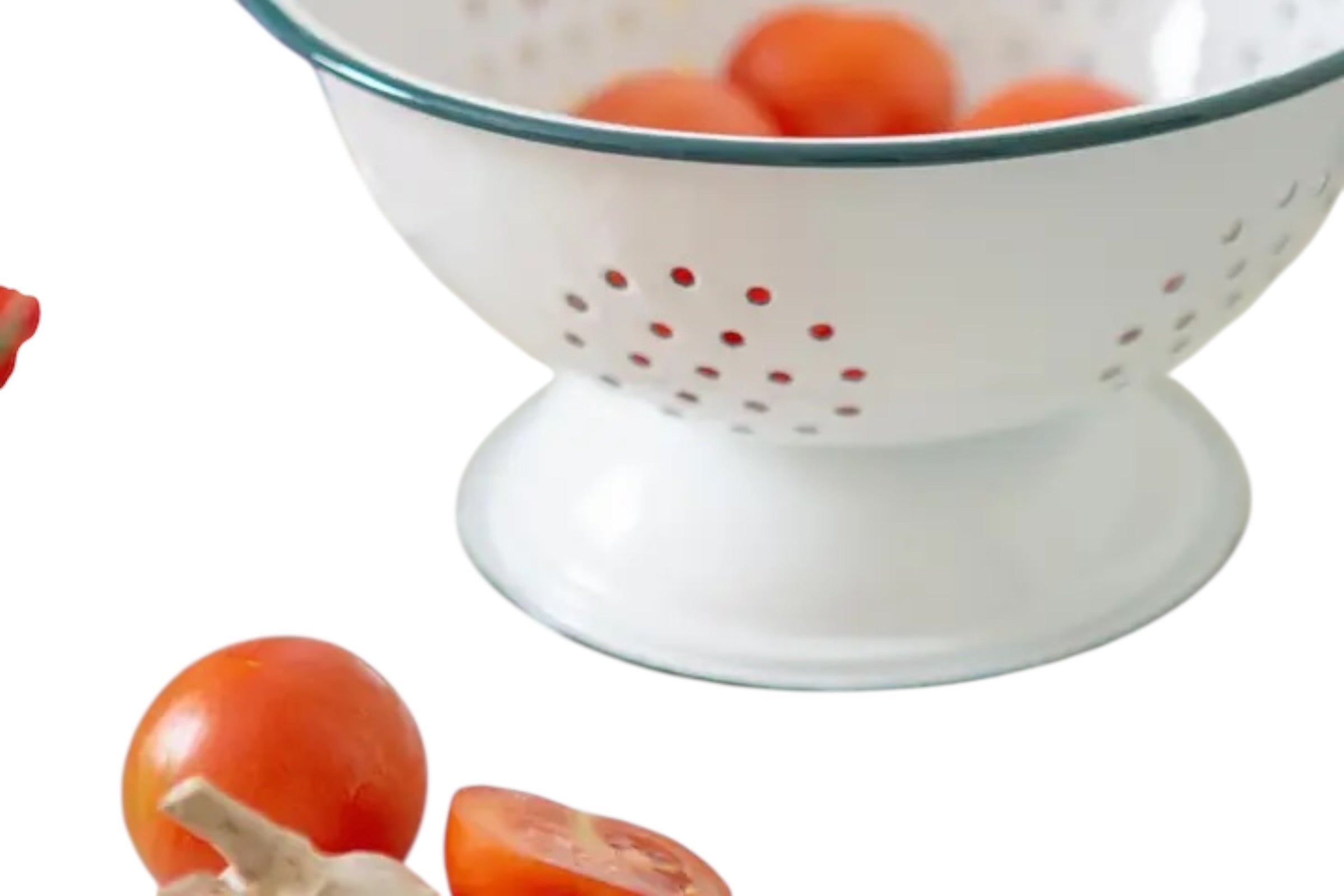 A close up of an enamelled steel colander finished in white with green accents. Set against a white background.