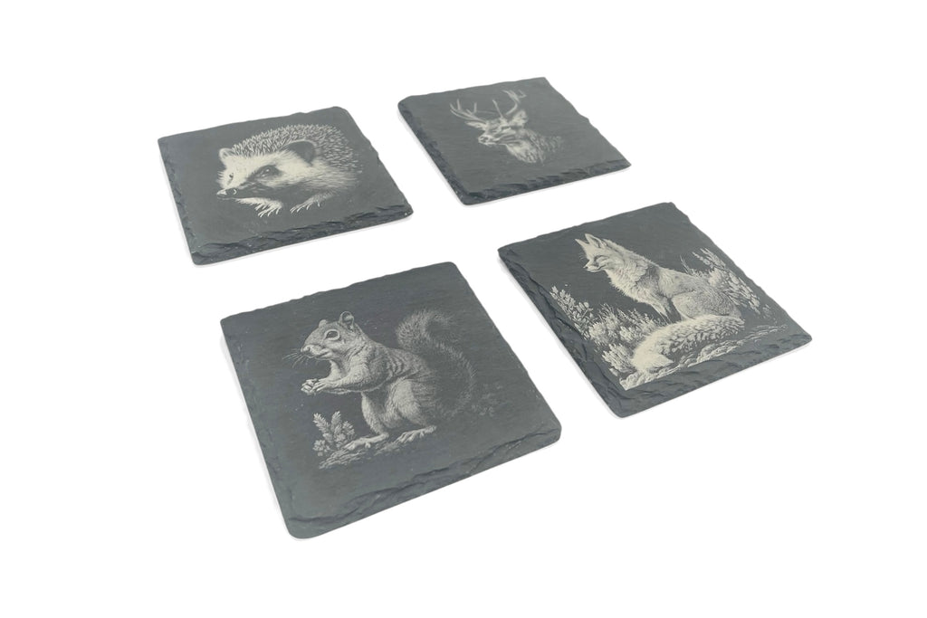 Four slate coasters with UK wildlife images laser etched into the surface, on a white background.