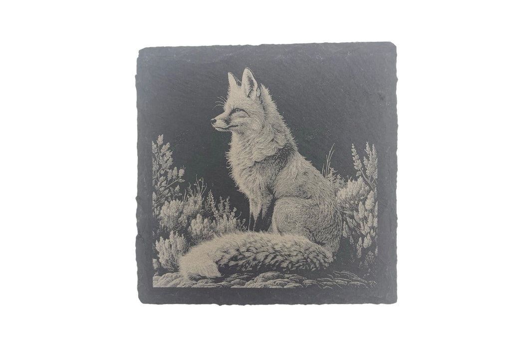 A slate coaster with the image of a fox laser etched into the surface, on a white background.