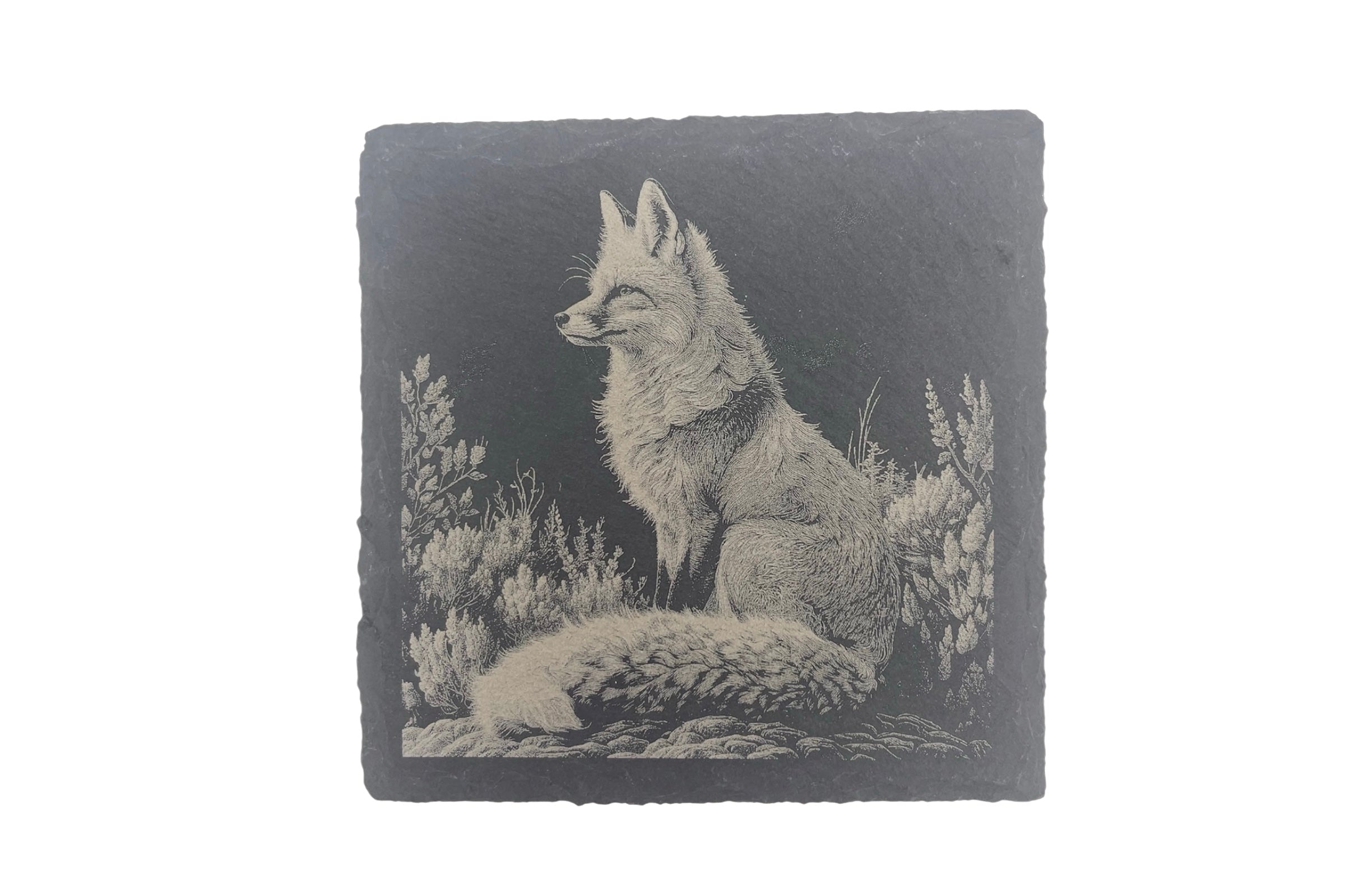 A slate coaster with the image of a fox laser etched into the surface, on a white background.