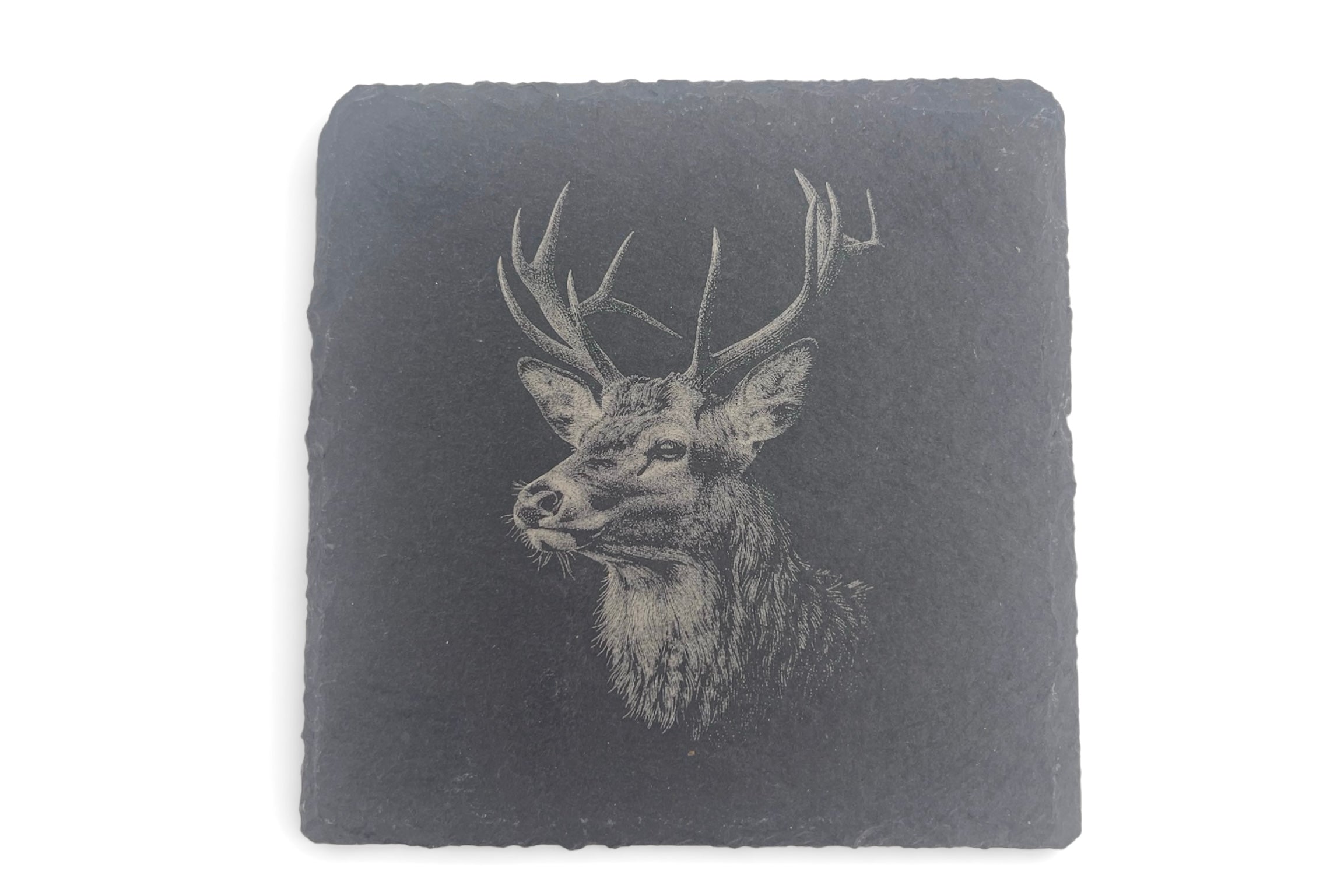 A slate coaster with the image of a stag laser etched into the surface, on a white background.
