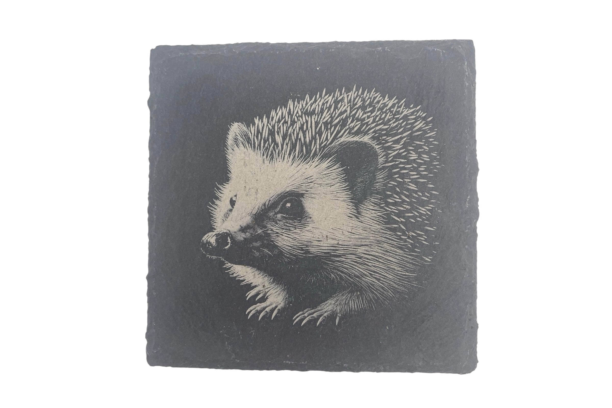 A slate coaster with the image of a hedgehog laser etched into the surface, on a white background.