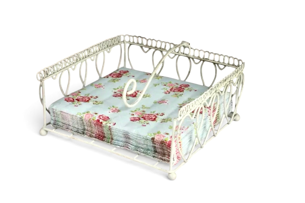 FINCHCRAFT cream wire napkin holder with decorative heart-shaped metal frame and weighted arm holding floral napkins.