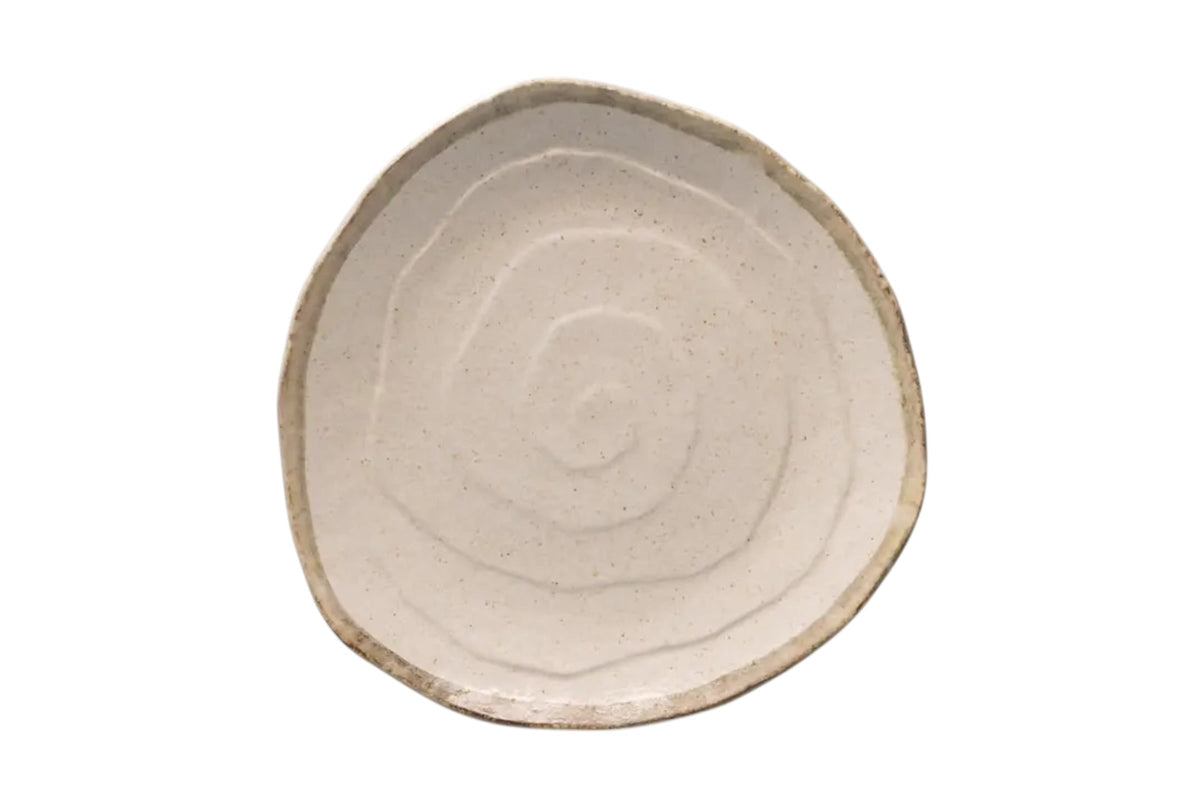 FINCHCRAFT flax-toned porcelain dinner plate with an irregular faceted outline and subtle spiral relief surface.