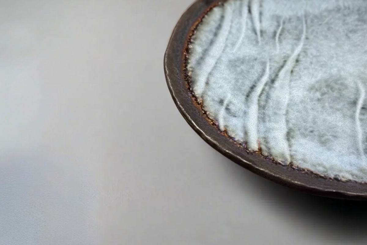 FINCHCRAFT grey glazed stoneware plate with a natural bisque edge and irregular, tactile surface texture.