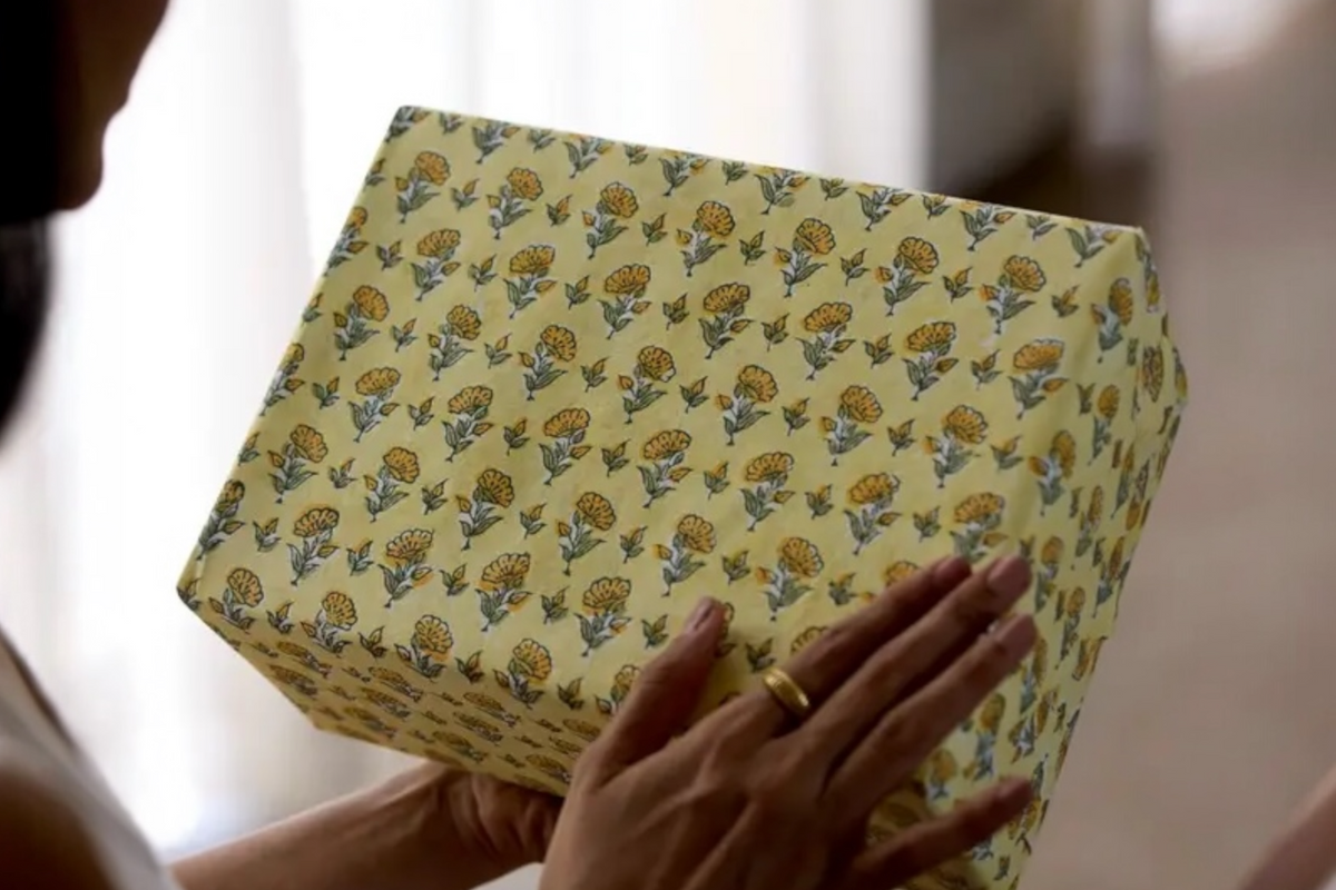 FINCHCRAFT sunshine yellow cotton wrapping paper with a hand block printed ditsy floral pattern on a gift box